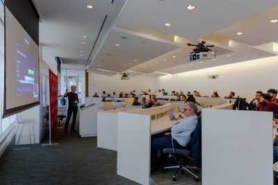 group of people in a room listen to a lecture