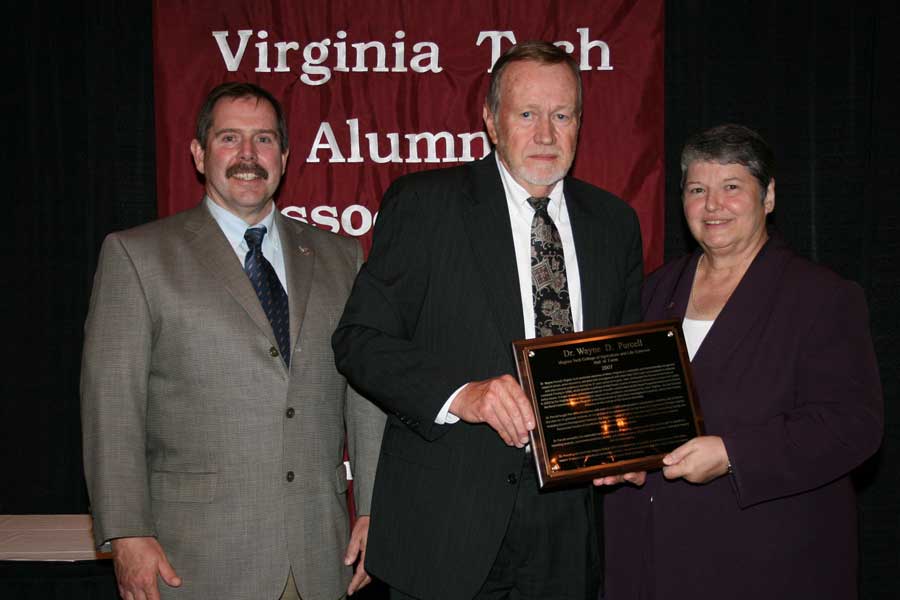 Wayne Purcell, alumni distinguished professor emeritus of agricultural and applied economics (center), received the College of Agriculture and Life Sciences Hall of Fame award from Kevin Boyle, head of the Department of Agricultural and Applied Economics (left) and Sharron Quisenberry, dean of the College of Agriculture and Life Sciences.