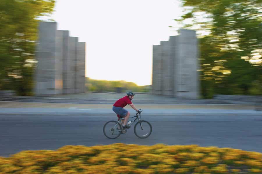 A student rides a bicycle on campus.