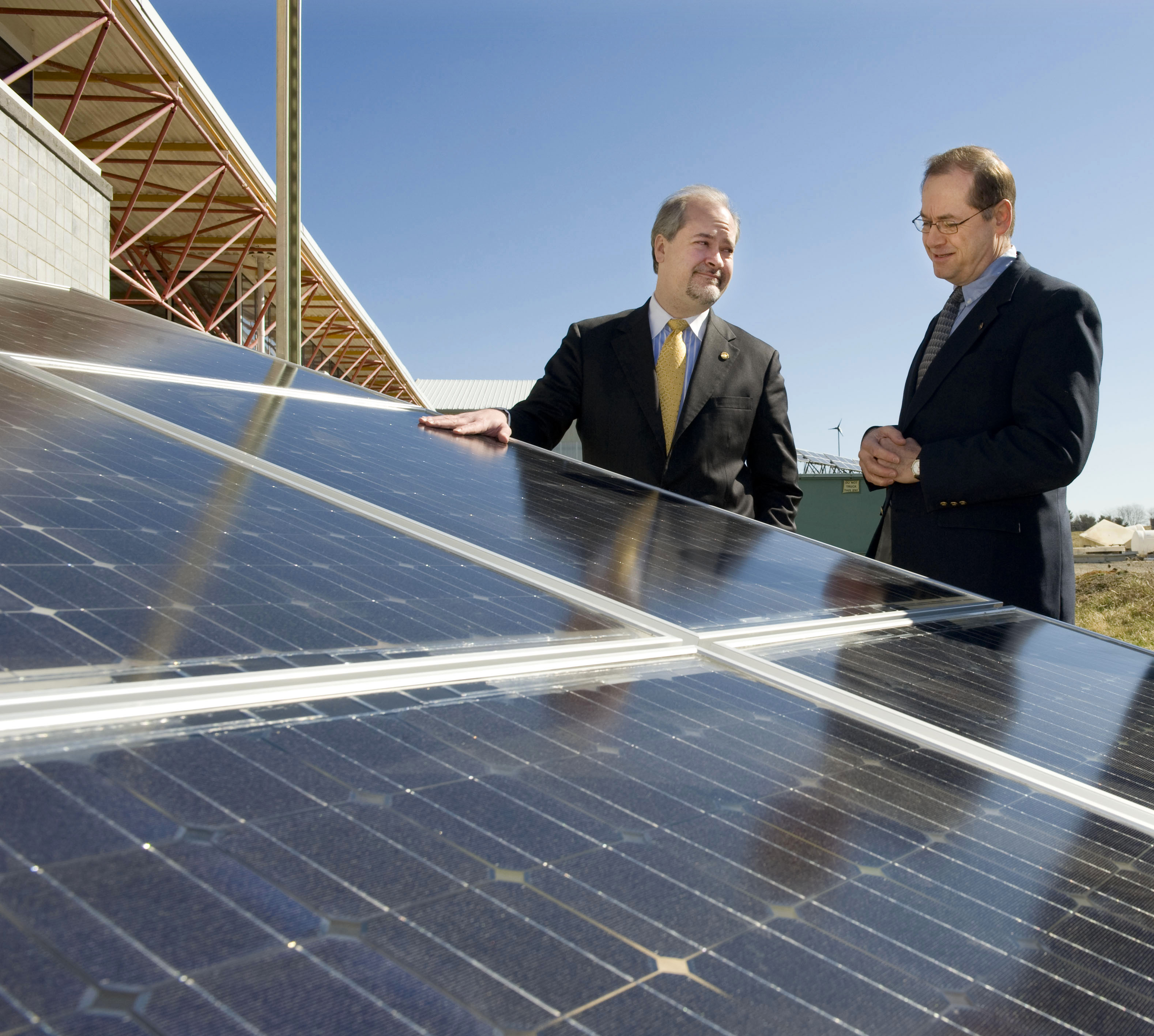 Virginia Secretary of Natural Resources Preston Bryant (left) and College of Architecture and Urban Studies Associate Dean of Research Robert Schubert with the solar panels that will soon be installed on the roof of the solar house Virginia Tech is designing and constructing for the U.S. Department of Energy Solar Decathlon.
