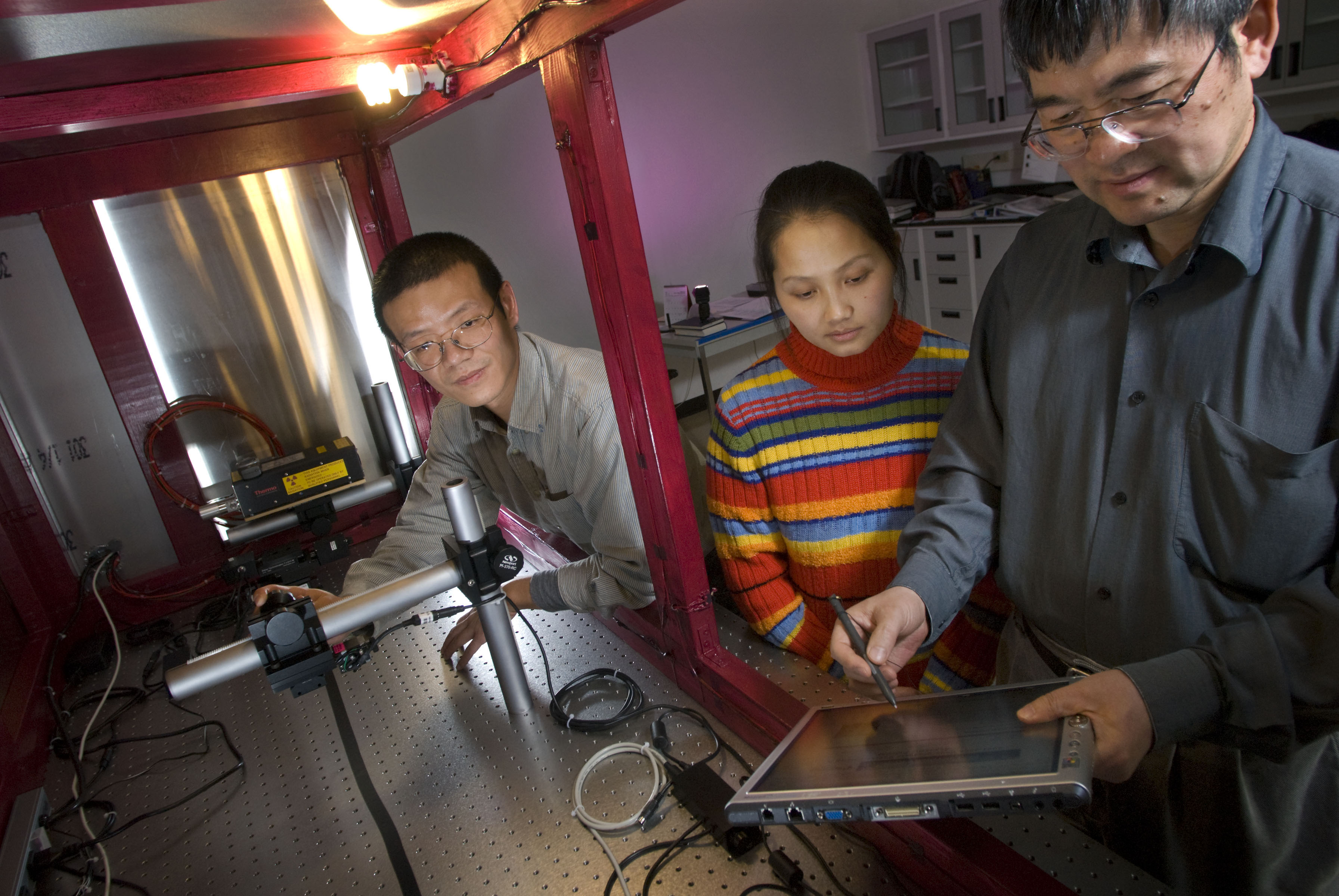 Ge Wang, far right, Virginia Tech director of the Virginia Tech-Wake Forest University School of Biomedical Engineering Sciences' biomedical imaging division, works in his nanoscale fabrication characterization research laboratory with Haiou Shen and Fang Liu of biomedical engineering. 