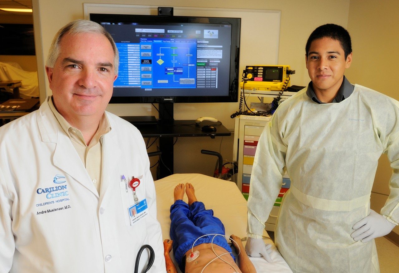 At a practice emergency room facility, Dr. Andre A. Muelenaer Jr. (left) and Virginia Tech College of Engineering graduate student Carlos Guevara display the large-screen digital format of the Broselow Tape, developed in conjunction with the college, Carilion Clinic Children’s Hospital and the tape’s original creator, James Broselow.