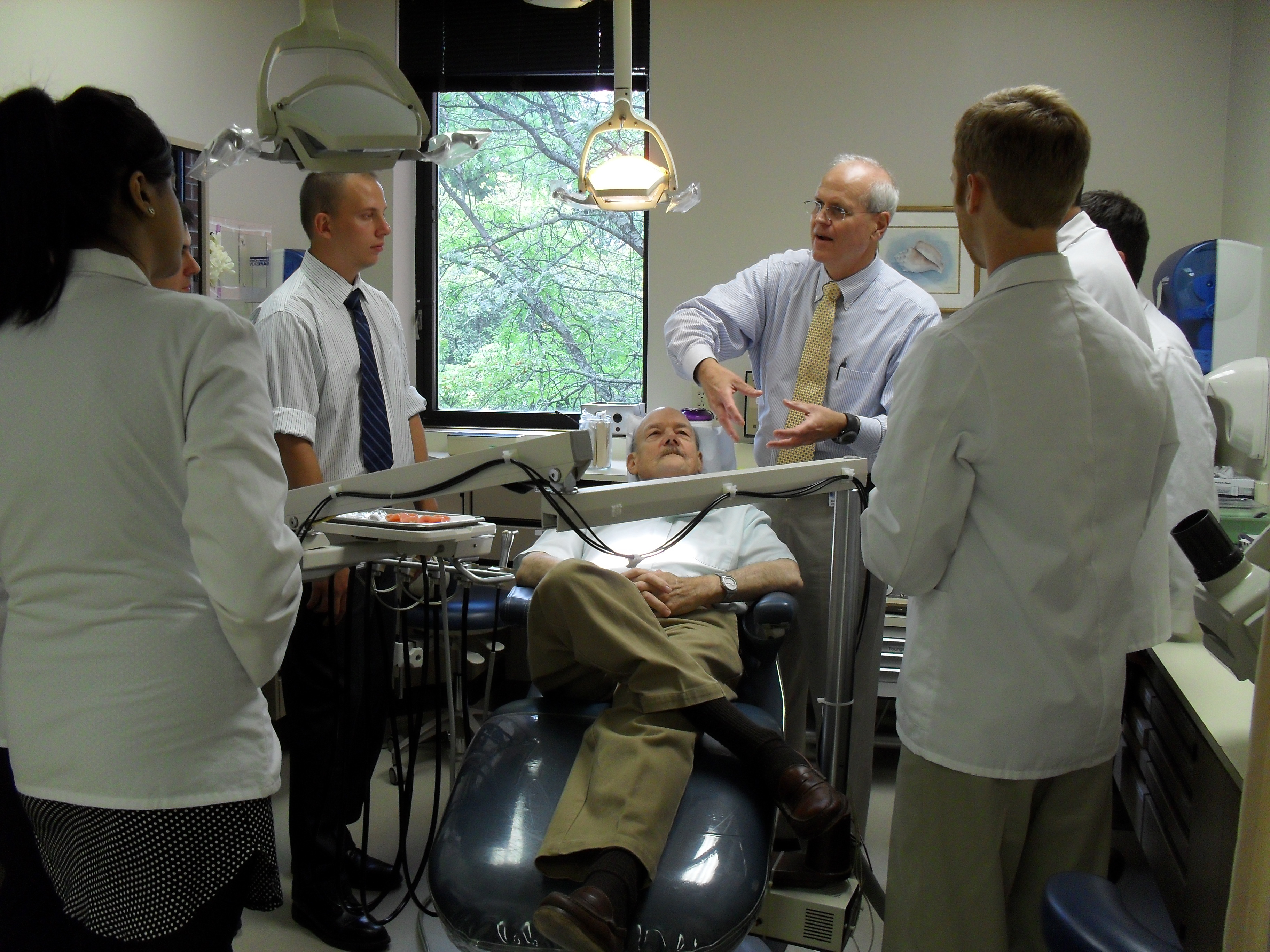 Charles "Bud" Conklin, DDS, teaches VTC School of Medicine students how to perform an oral exam.