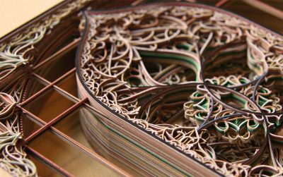 A close-up view of layers of intricately cut paper.