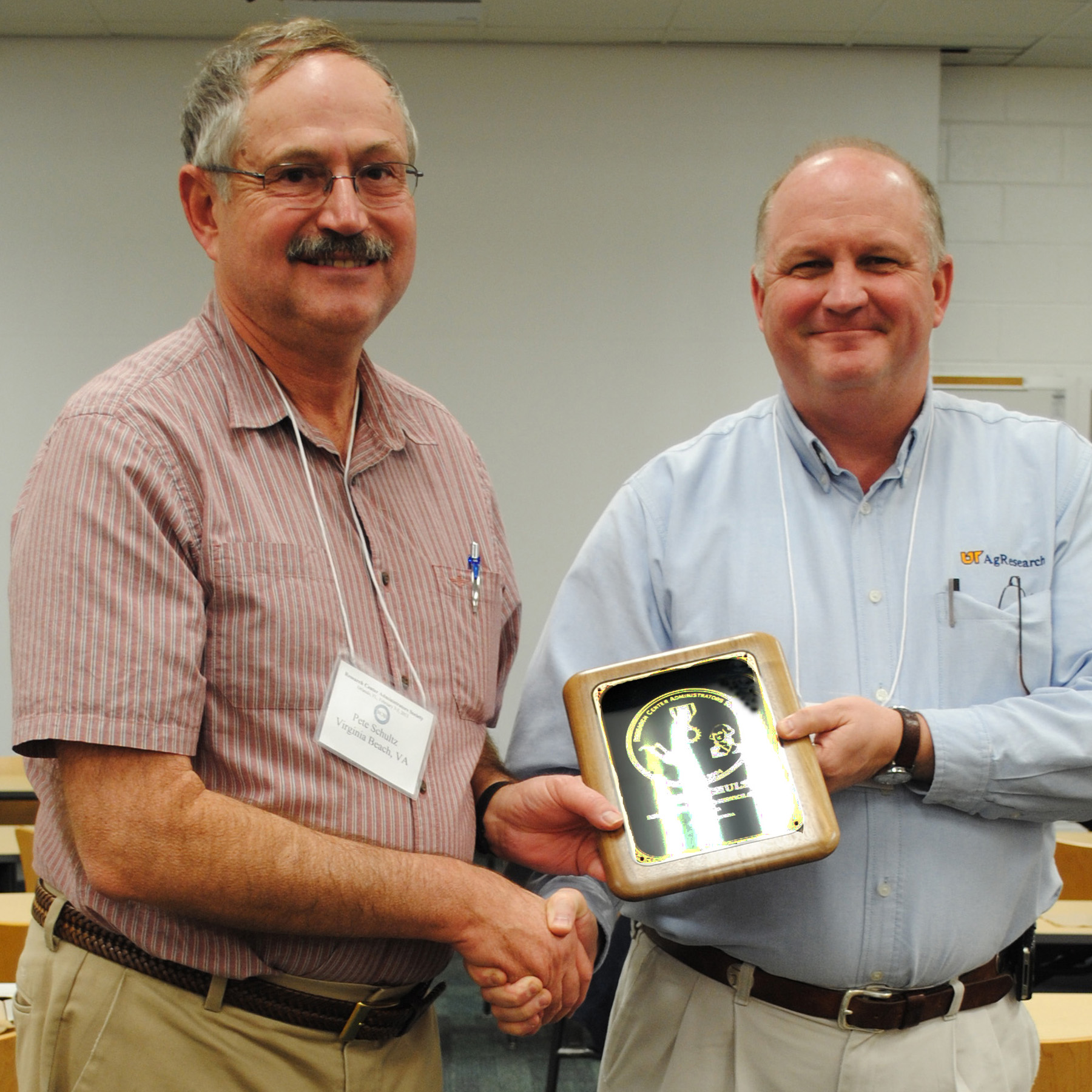 Walt Hitch presents Peter Schultz with the Distinguished Service Award from the Research Center Administrators Society of the United States.