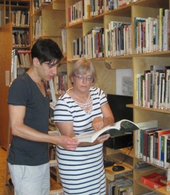 Marlene Koenig and student Nicolas Balacco looking at a book in the Virginia Tech library