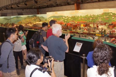 John White and students stand before a large diorama of the town of Pulaski inside the transportation museum