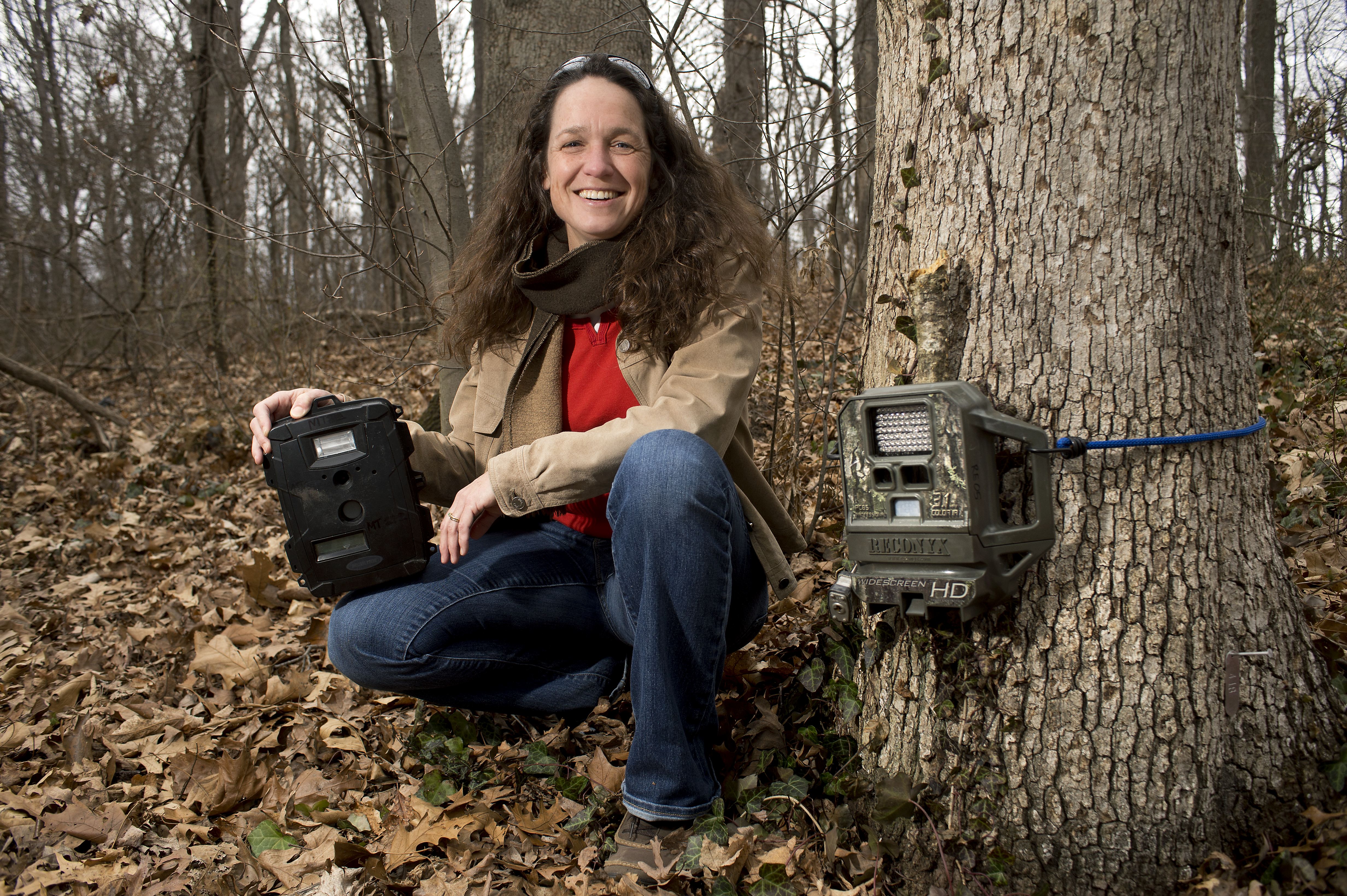 Marcella Kelly in the woods with a camera trap