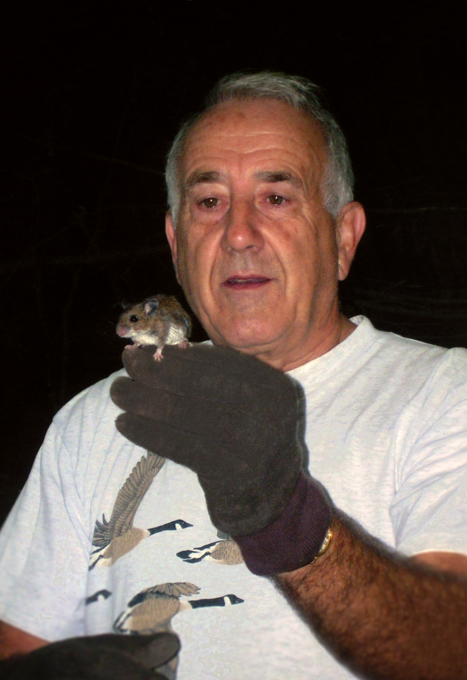 Donald Linzey in the woods holding a deer mouse