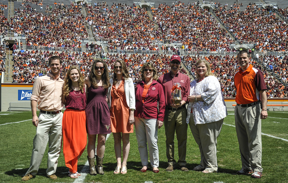 Thomas Clements; Heather Hicks; Mikayla Meyer; Amanda Clements; Faith Hicks; Alan Hicks; Patty Perillo, vice president of Student Affairs; and Rick Sparks, associate dean, New Student and Family Programs stand on the football field