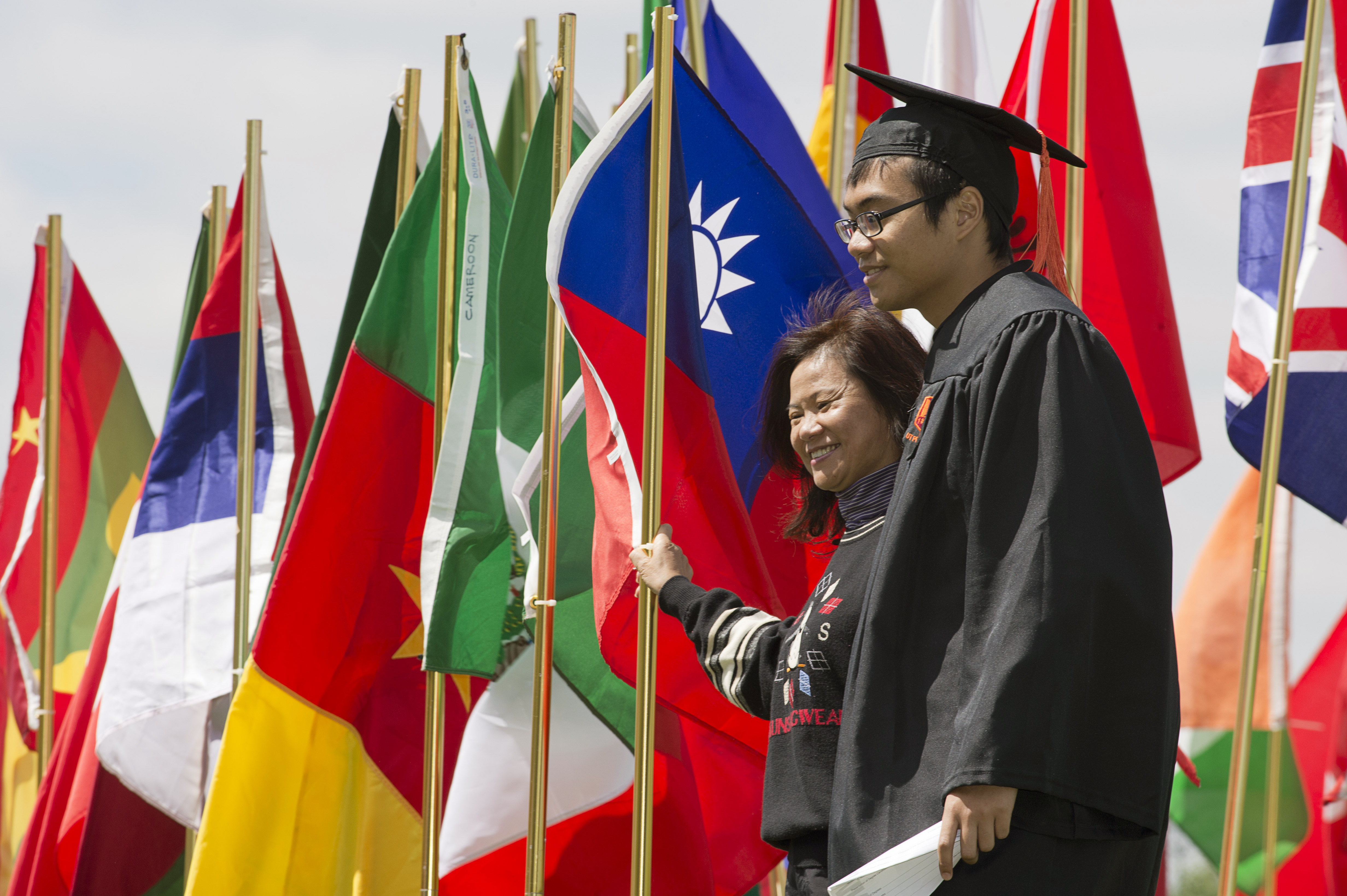 Families of international students posing with graduates and international flags
