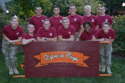 Team image of Esprit de Corps posing with the push-up board, wearing army pants and maroon shirts