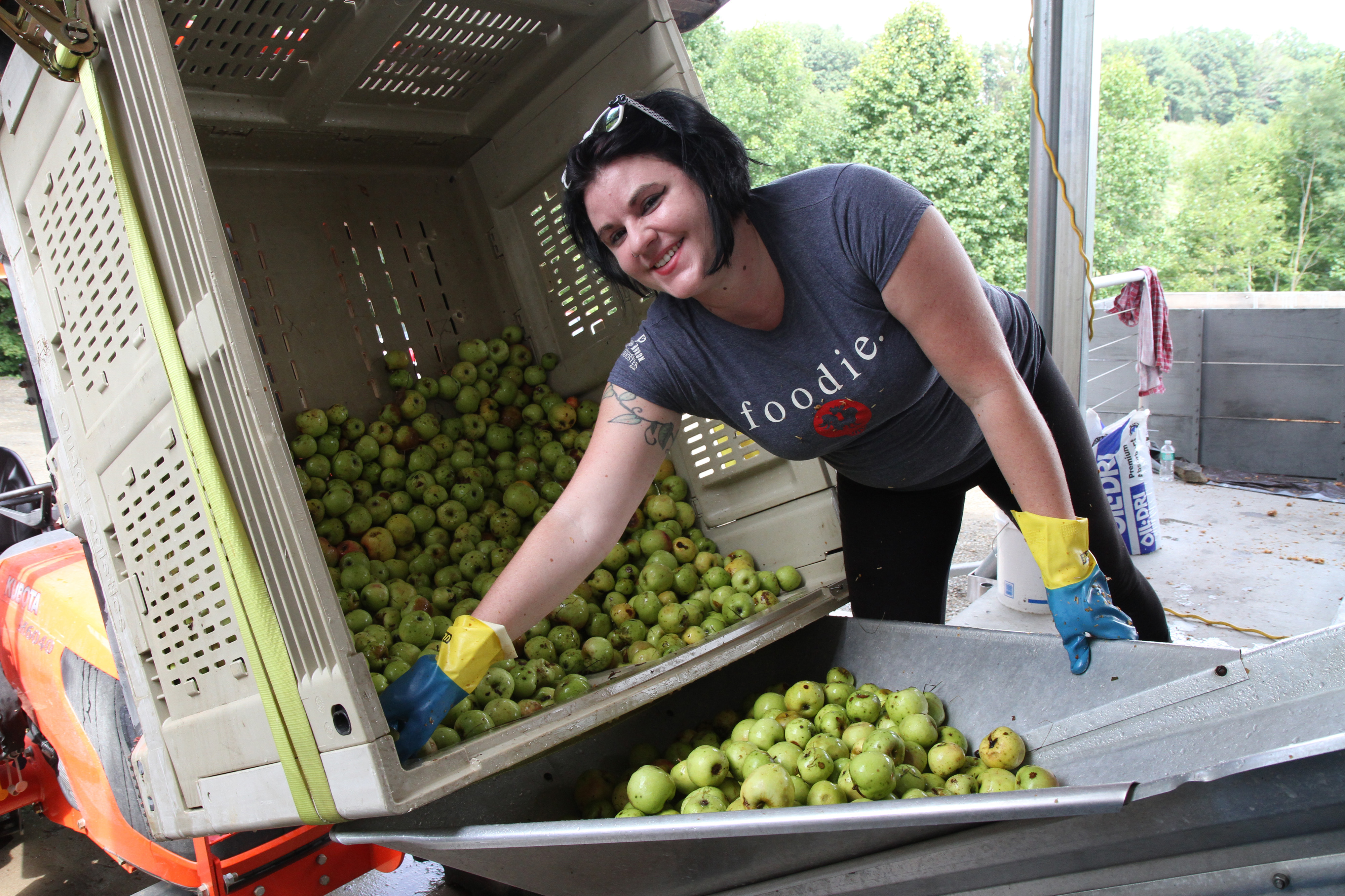 Meg McGuire leans over a barrel of apples