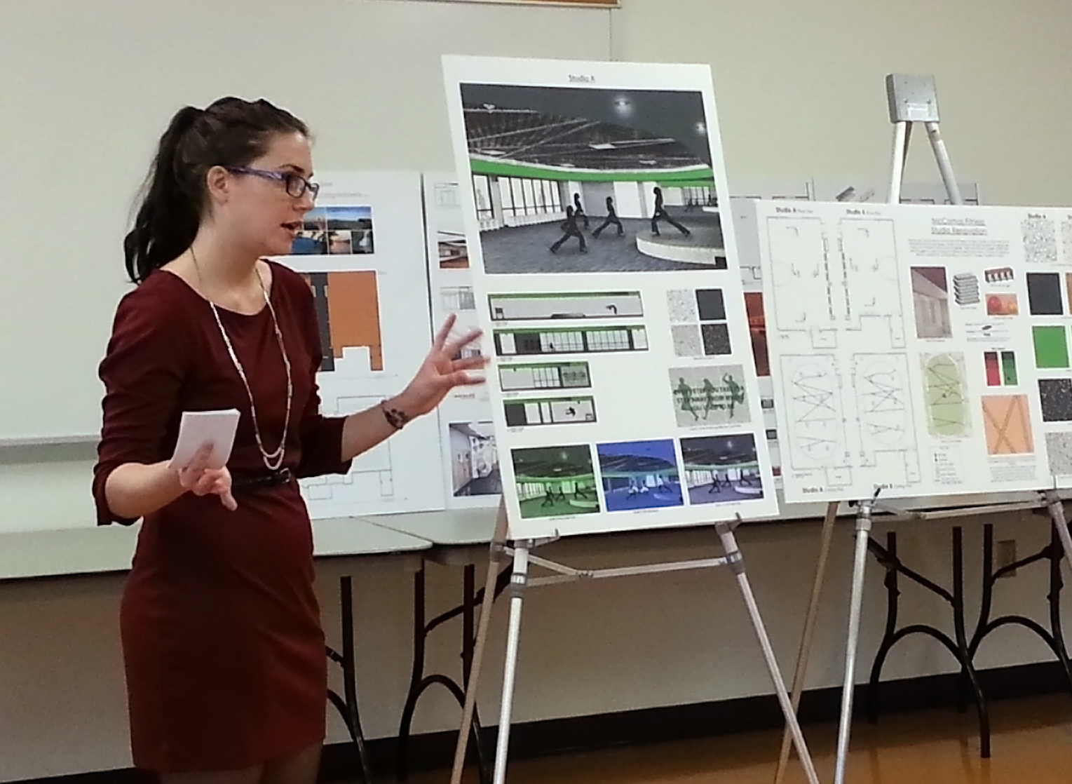 Young woman presents design boards for fitness studios.