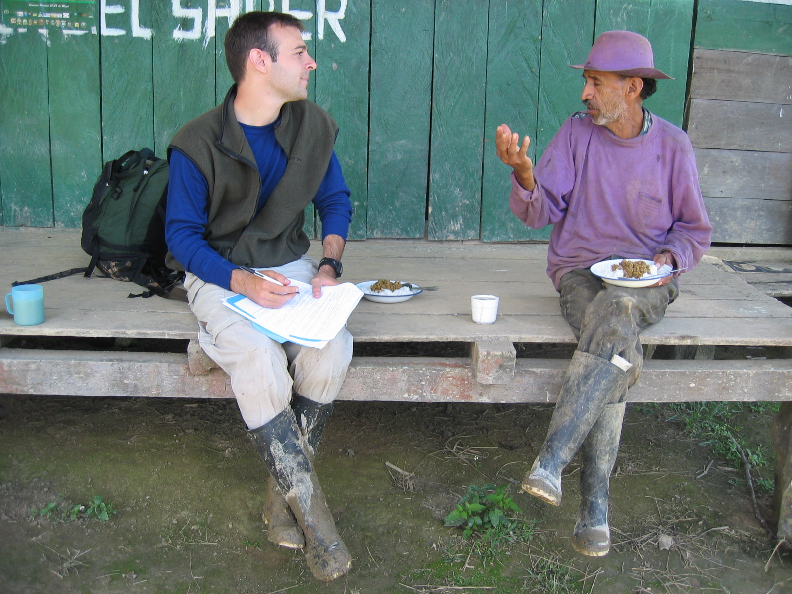 Two people sitting on a small deck.