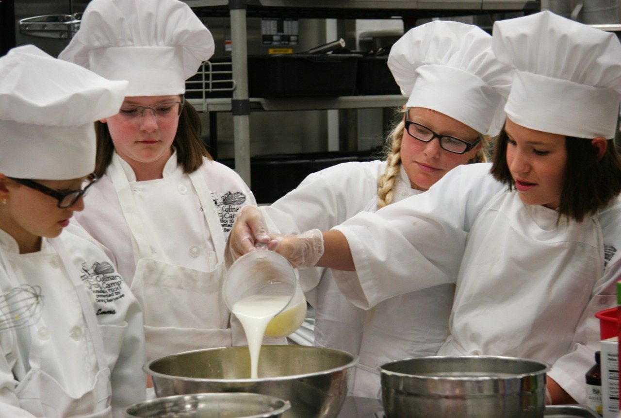 Campers from the 2014 Basic Culinary Camp work together to make batter for French toast.