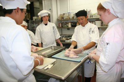 Chef and Culinary Camp students work with a whole chicken 