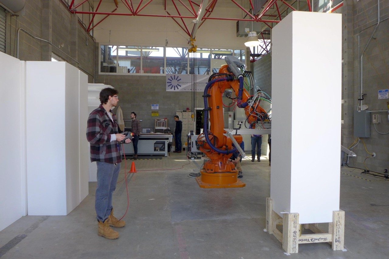 A summit participant works with the large robot in the Design Robotics Studio.