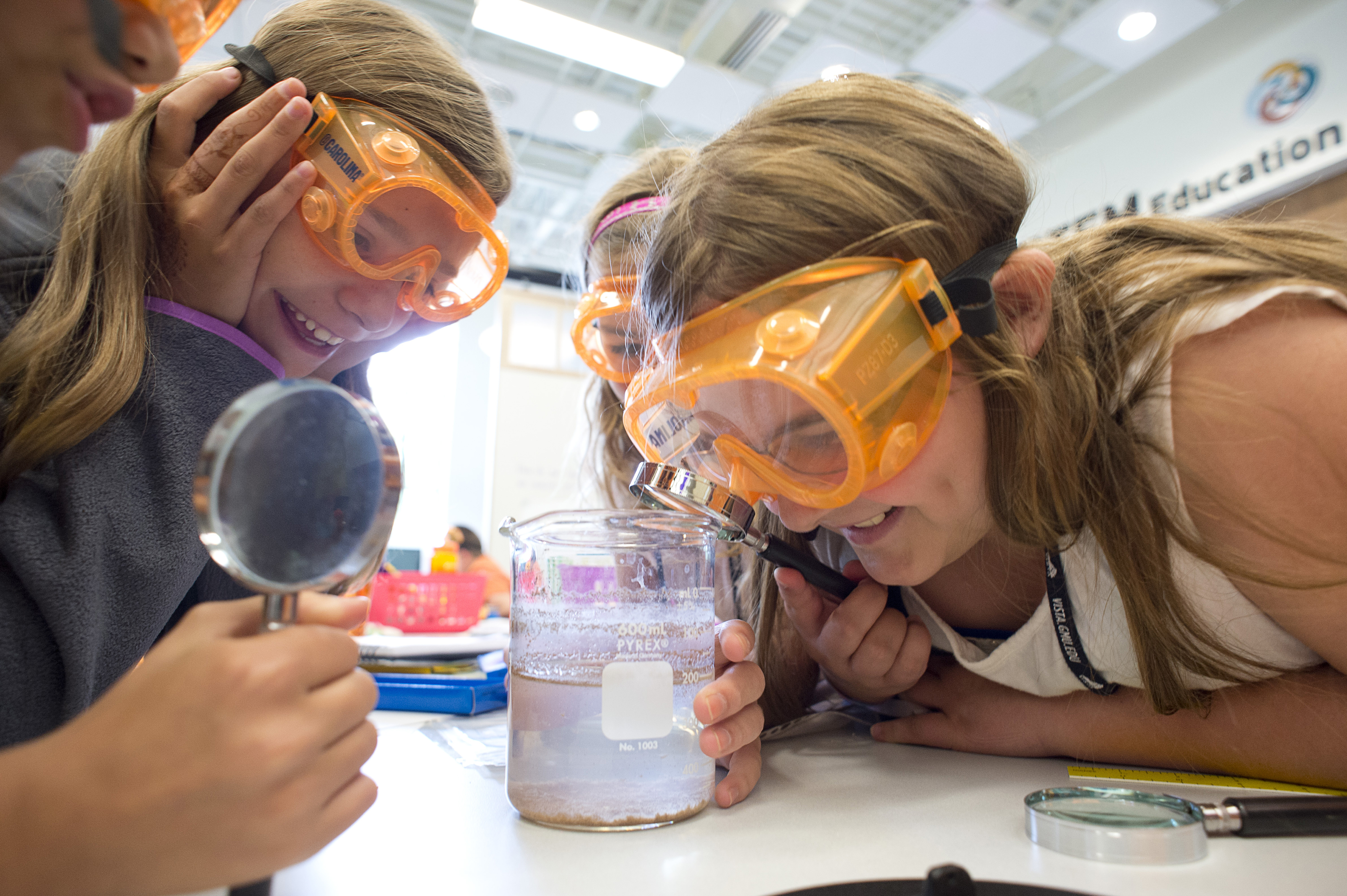 Kids with goggles, beaker, hand lens