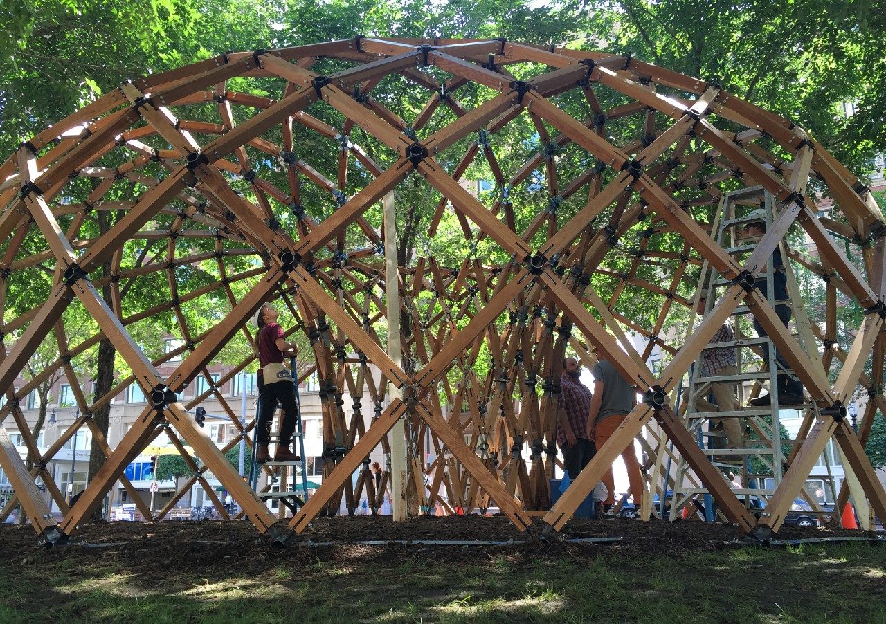 A team works to assemble the Lo-Fab Pavilion on the Rose Kennedy Greenway in Boston. 
