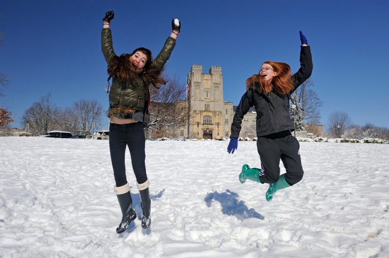 Students jumping in snow on the Drillfield