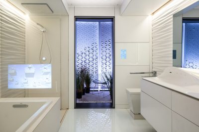 The FutureHAUS' full bathroom, which boasts actuators that can raise and lower the vanity and toilet. A sensor embedded in the glass floor can detect if occupants slip and fall, and can send alerts in an emergency. (Photo by Erik Thorsen)
