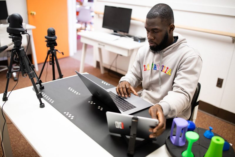 A College of Engineering Graduate student works on a laptop at a desk.