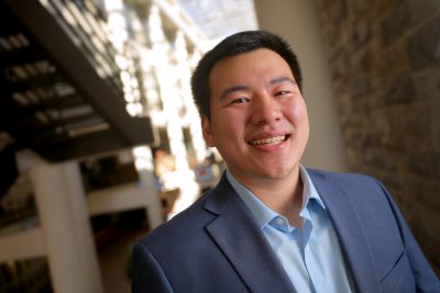 Andrew Luo poses in the atrium of Pamplin Hall.