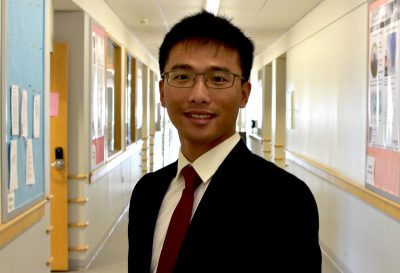 In this photo from 2016, Assistant Professor Feng Lin poses wearing a suit and tie at Hahn Hall North.