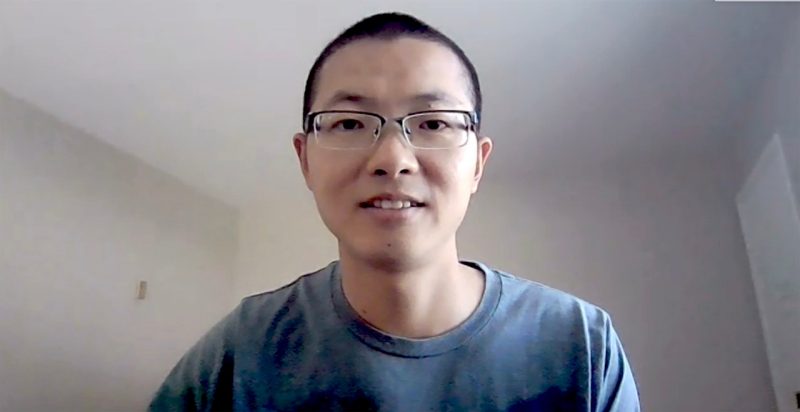 Guang Zhai, wearing a blue t-shirt, from his office in Berkeley, California, during a Zoom call. Screenshot by Steven Mackay.