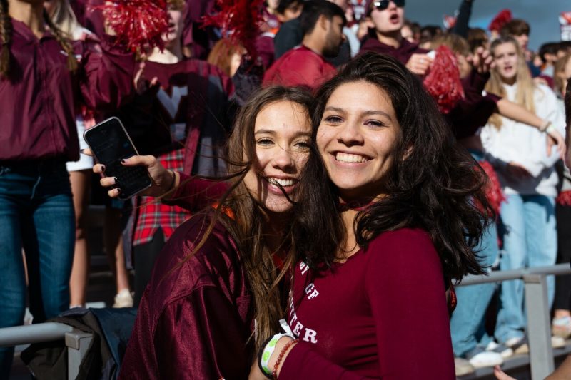 Two women pose together in the crowded stands of Lane Stadium.