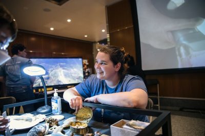 A grad student displays mussels at the Benthos 360 exhibit at the ACCelerate Festival