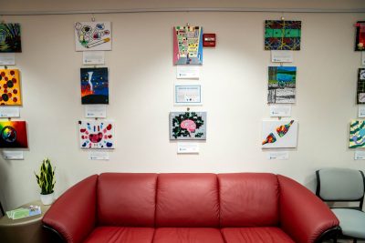 Student art adorns the wall behind a comfy couch in the Center for Inclusion. 
