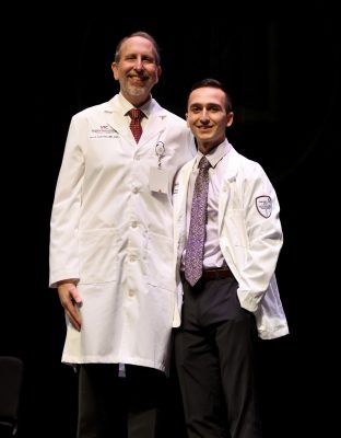 VTCSOM Dean Lee Learman poses on stage with first-year student Parsa Khaksar, who received his white coat.