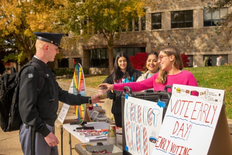 Maya Mahdi, a Virginia Tech senior who founded Hokies Vote Caucus, hands out hot chocolate to students on campus, while encouraging them to register to vote. Photo by Savannah Webb for Virginia Tech.