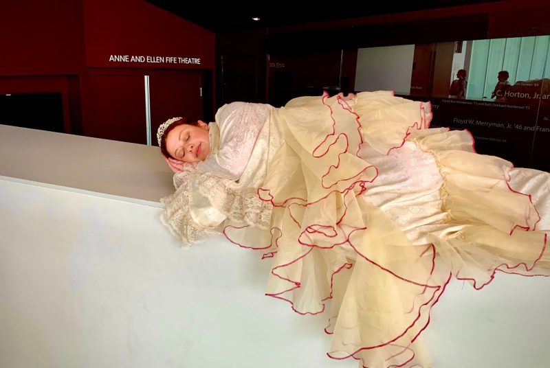 Student actress Maya Jaffe, dressed in a white gown with many ruffles, takes a nap during rehearsal for the musical  "Once Upon A Mattress."