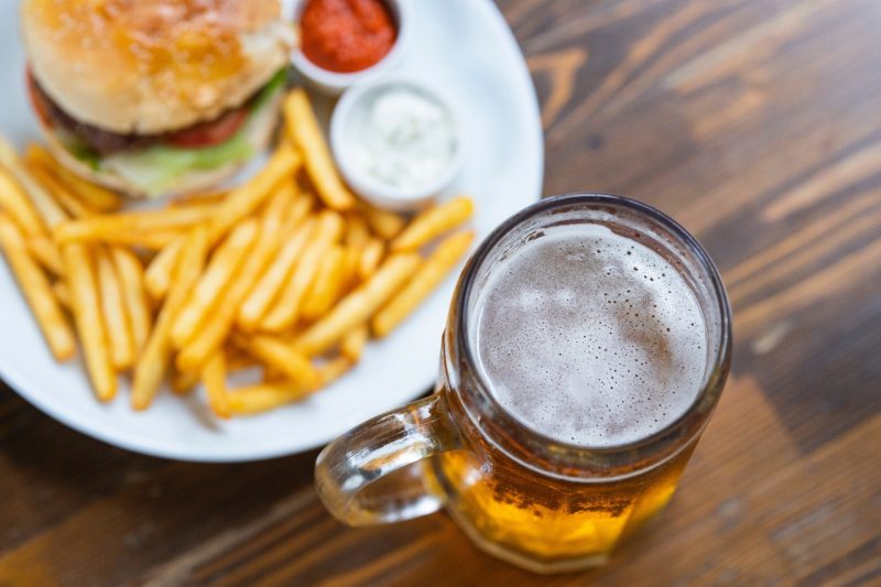 A mug of beer and a burger with fries