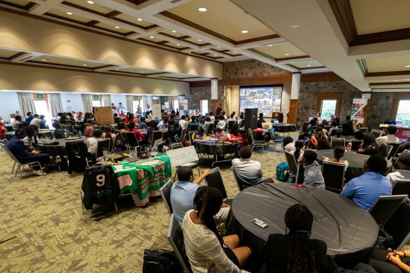 High school students sit at round banquet tables during a college and career fair session of the Black College Institute.