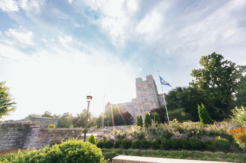 The sun shines behind Burruss Hall on a recent summer day.