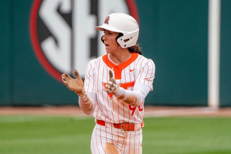 Emma Ritter in an orange and white striped softball uniform.