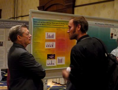 George Flick and a colleague discuss research at a poster session during the International Conference on Recirculating Aquaculture, Roanoke, Va. Photo by Angela Correa for Virginia Tech.
