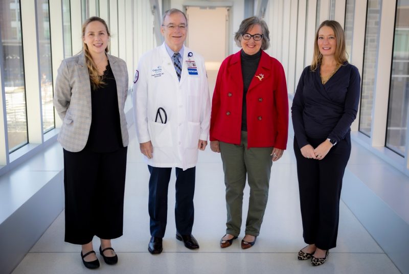 Four individuals side-by-side, one wearing a physician's white coat