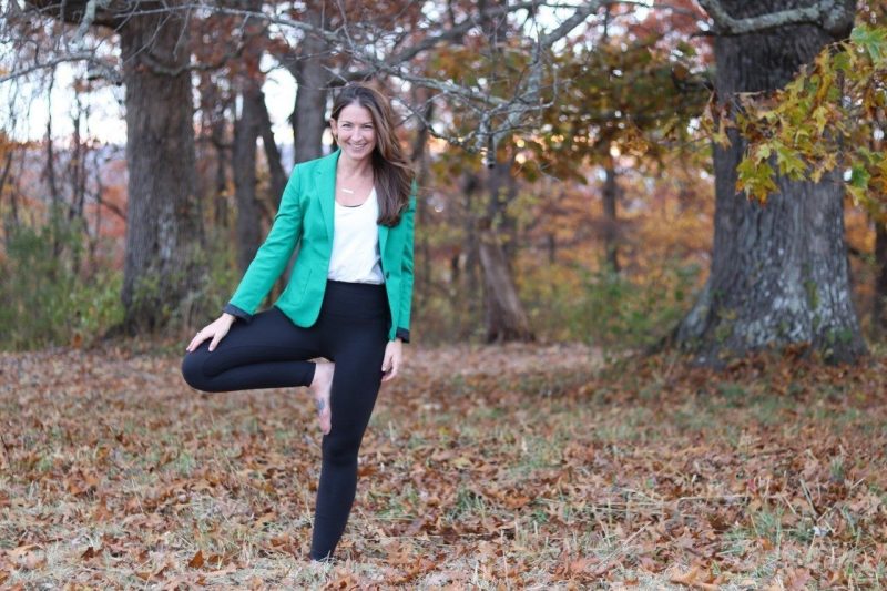 Samantha Harden stands in a yoga pose outside in the woods.