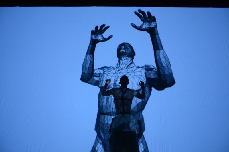 Scotty Hardwig with motion capture devices and his 3D avatar projection mimicking his movement during the performance . Photo courtesy of Nate King.