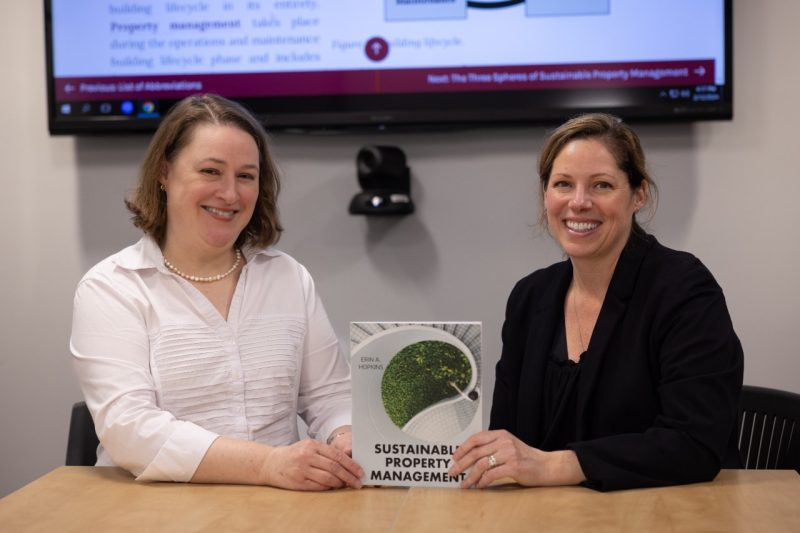 Anita Walz and Erin Hopkins with the "Sustainable Property Management" textbook. Photo by Chase Parker for Virginia Tech