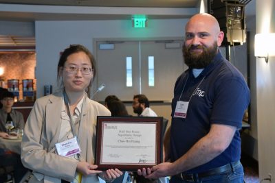 Student and award representative pose with award certificate.