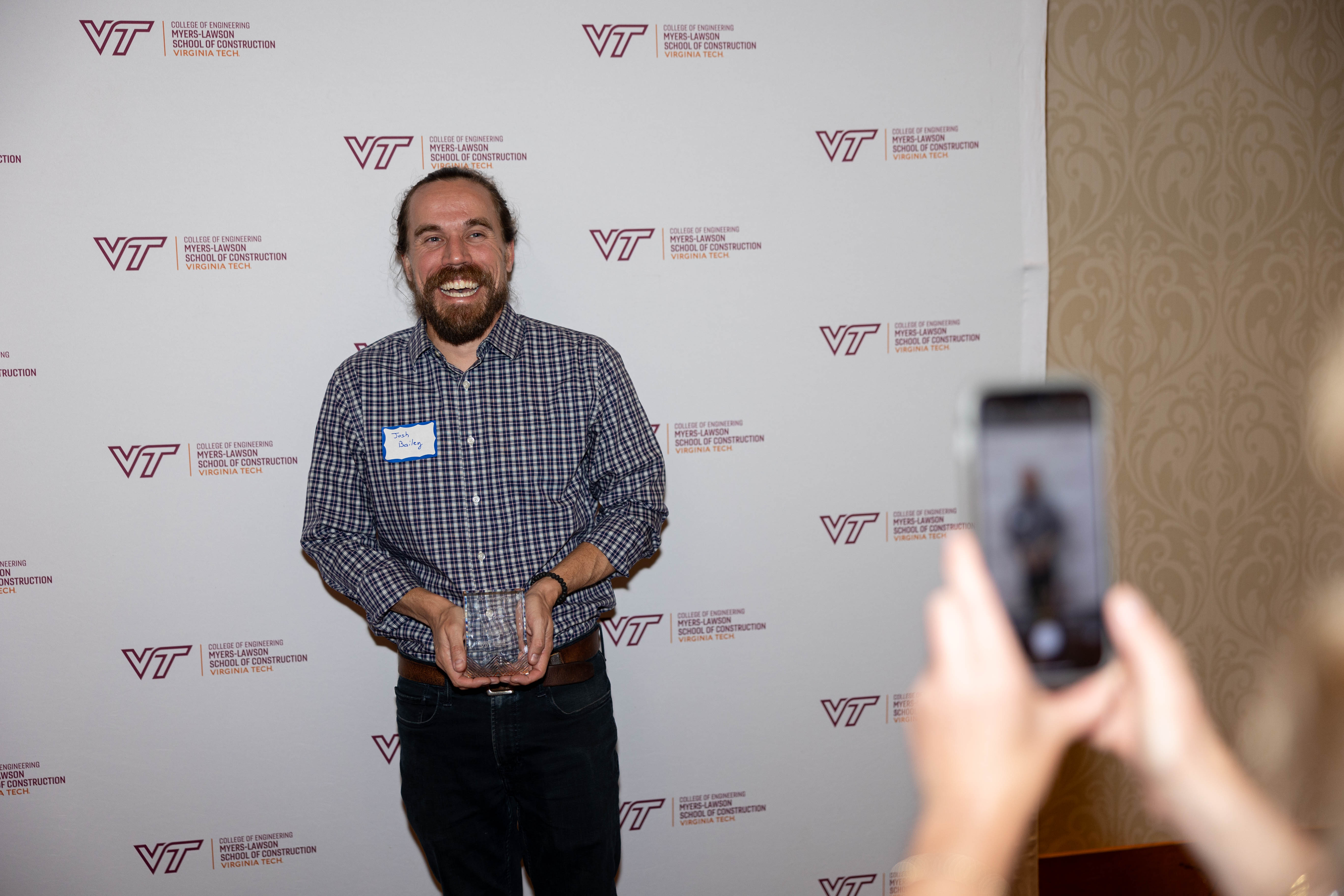 Joshua Bailey '09 with the Outstanding Building Construction Alumni Award. Photo by Will Drew for Virginia Tech.
