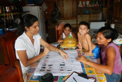 A group of people seated at a table, participating in a visual survey of regional animals. 