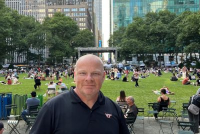 A person stands in a park in a city.