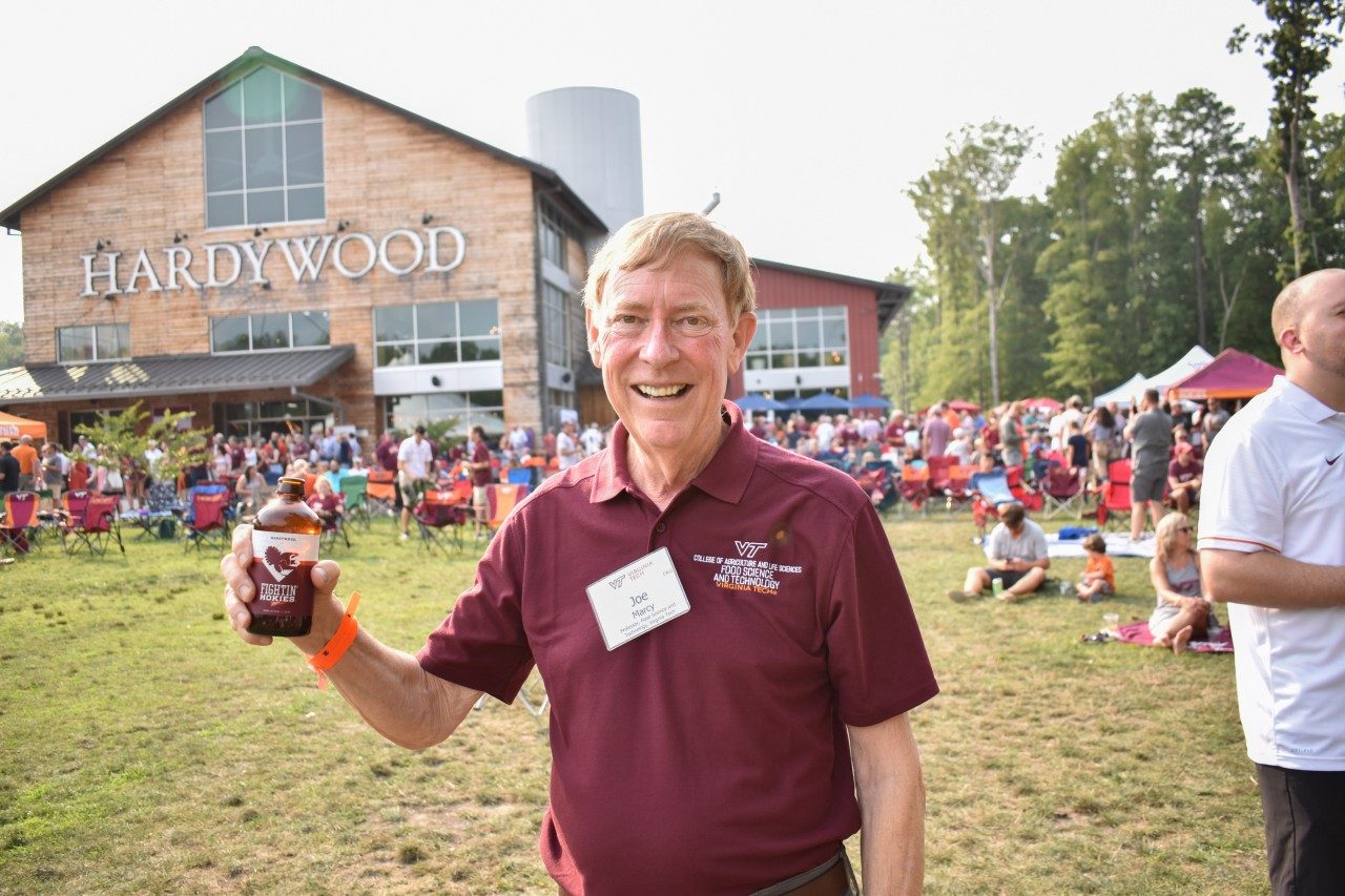 Joe Marcy holds up a Fightin' Hokies Lager at the beer's launch party
